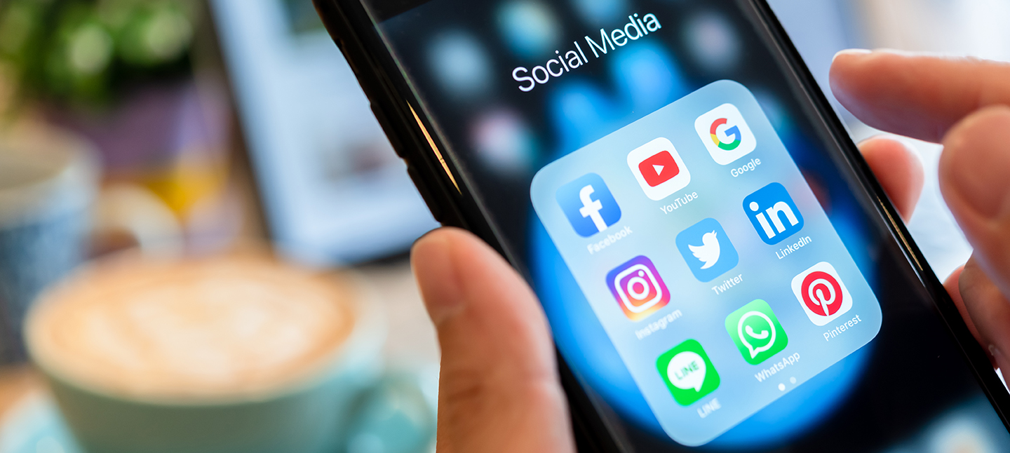 BANGKOK, THAILAND- 26 June 2019 : Hands of man use Iphone 7 plus with social media application of facebook, youtube, google search, instagram, twitter, linked in, line whatsapp, and pinterest on black background